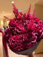 Букет из красных гортензий, остильбы и перцев в ярких crimson hues.