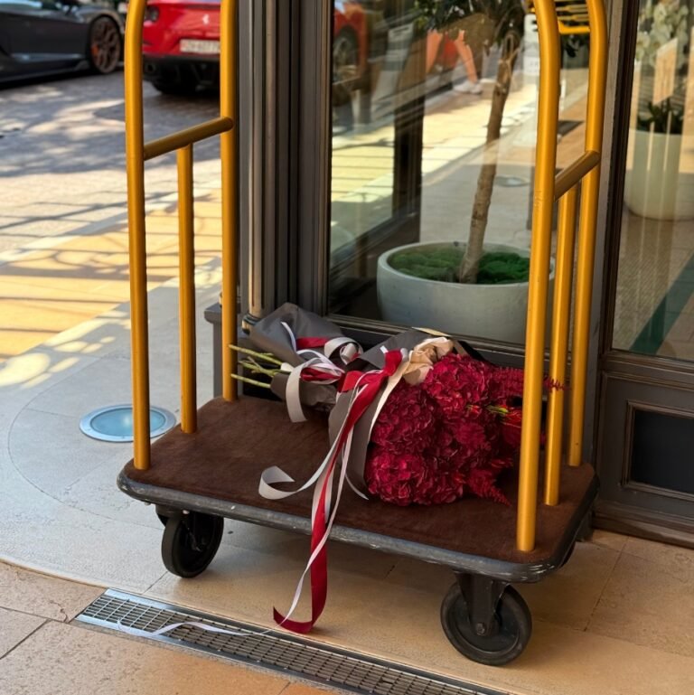 Crimson hues Букет с красными оттенками из гортензий и декоративных растений на тележке для доставки.