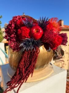 Autumn Осенняя композиция с золотой тыквой и яркими цветами в винных оттенках.